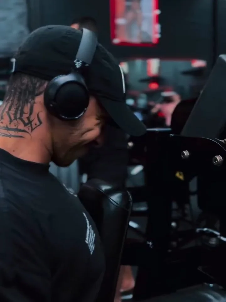 Kainã Soares de fone e boné durante o treino na academia